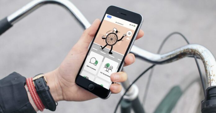 Abgebildet ist eine Hand, die ein Handy hält, auf dem die Cyclomania-App geöffnet ist.