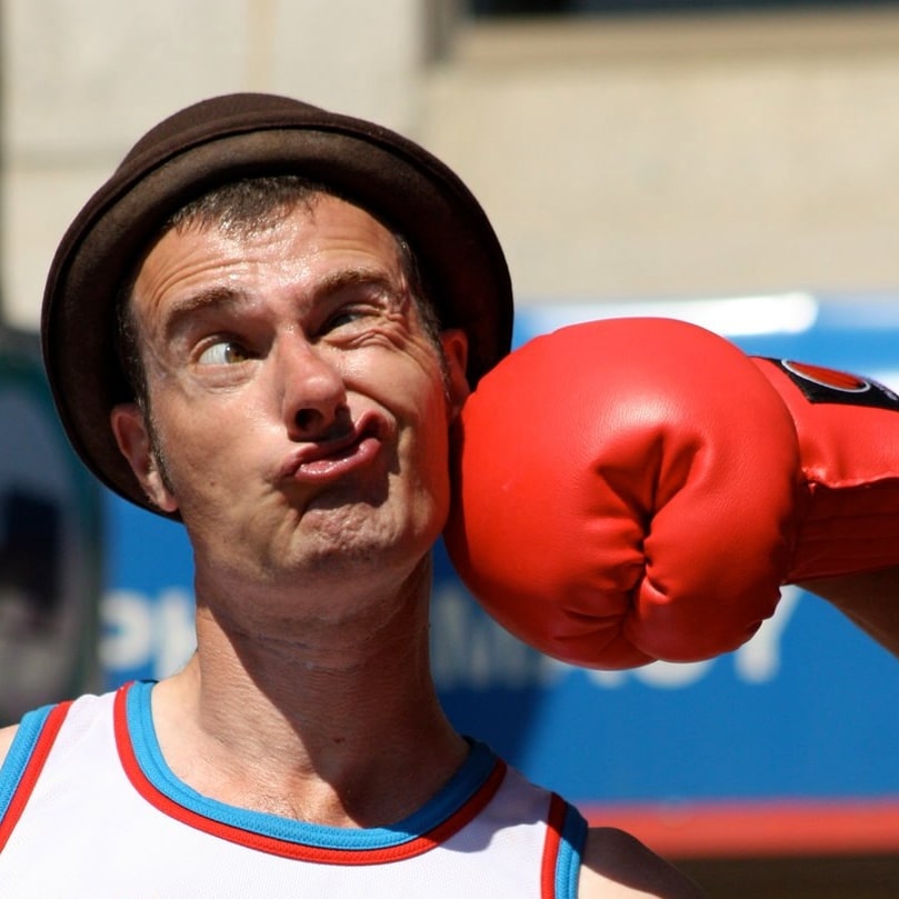 Gaukler wird von Boxhandschuh im Gesicht getroffen