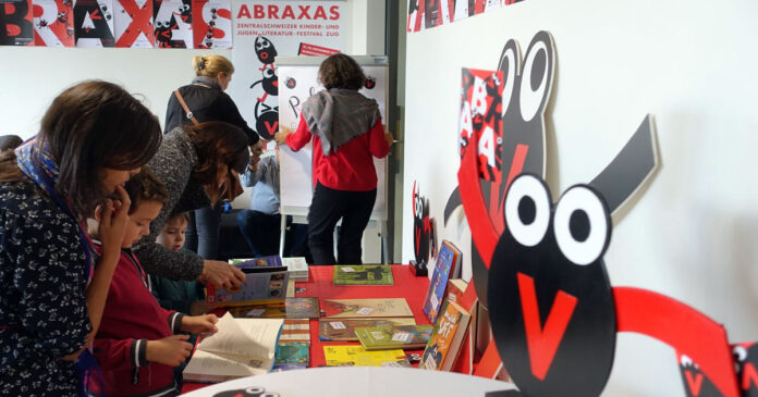 Besucher schauen sich die Buecher am Stand von Abraxas an