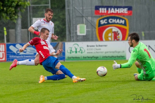 Ein SC-Cham-Spieler schiesst den Ball in Richtung Tor, der gegnerische Torwart streckt seine Arme zum Ball aus.