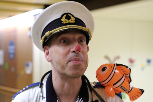 Portrait des Dr Ahoi in Seemannsuniform, mit rotem Punkt auf der Nase und einem aufblasbarem Clownfisch