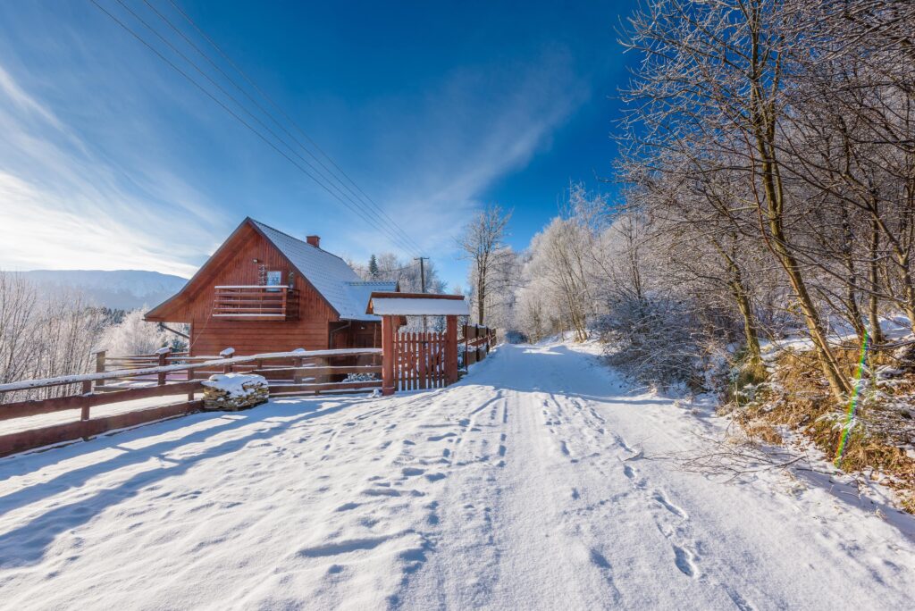 Eine Alphütte steht in einer Schneelandschaft.