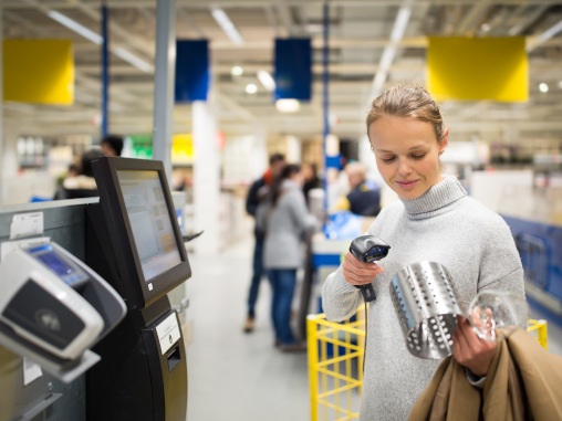 Junge Frau an Self-Checkout-Kasse im Supermarkt