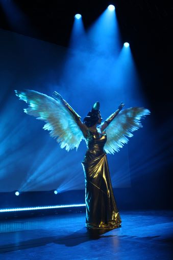 Eine Drag Queen mit Flügeln performt auf der Bühne