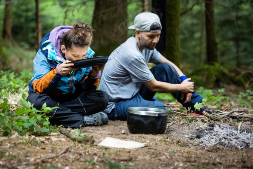 Zwei junge Menschen im Wald beim Essen