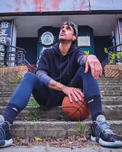 Jan Seven Dettwyler sitzt mit einem Basketball auf einer Treppe