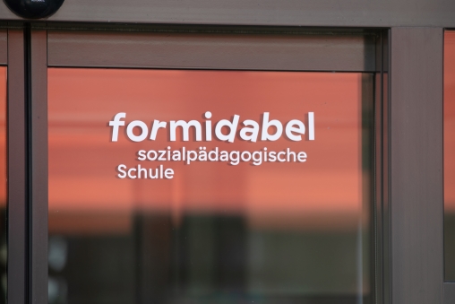 Beschriftetes Fenster. Scheibe der sozialpädagogischen Schule formidabel