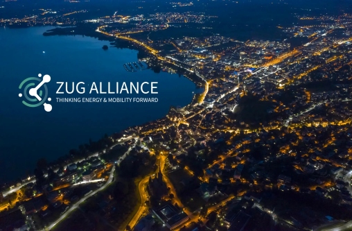 Blick auf die beleuchtete Stadt Zug mit dem Logo der Zug Alliance